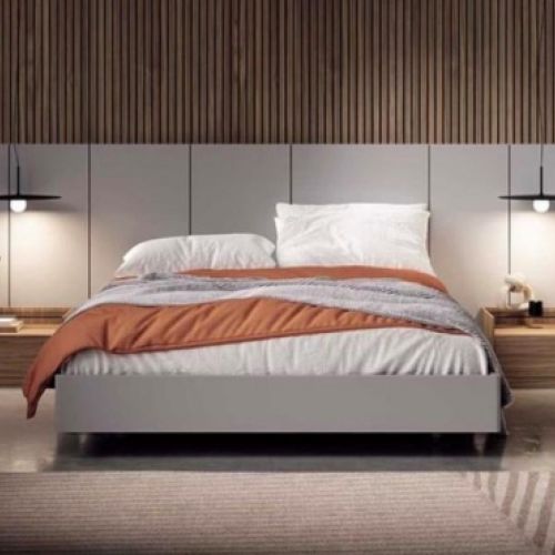 Primer plano de cama grande de dormitorio con dos mesillas anchas de baja altura