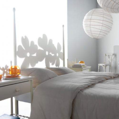 Detalle de dormitorio con decoración de láparas redondas y pared iluminada
